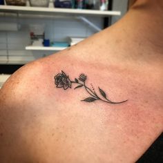 a woman's shoulder with a small flower tattoo on the left side of her chest