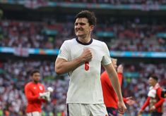 the soccer player is celebrating his team's victory at the game, with other players in the background