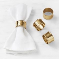 gold napkin rings and napkin on a marble surface