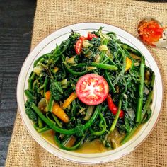 a white plate topped with green beans and veggies on top of a table