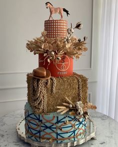 a three tiered cake is decorated with horses, hay and other things on it