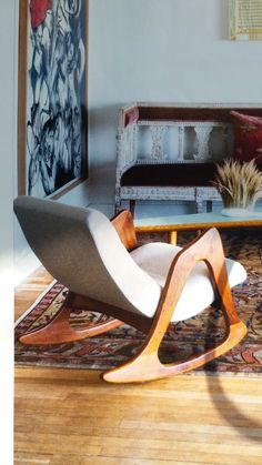 a living room filled with furniture next to a painting on the wall and wooden floor