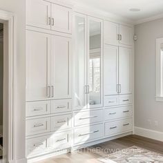 an empty room with white cabinets and wood floors