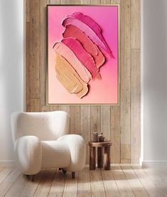 a white chair sitting in front of a pink painting on a wooden paneled wall