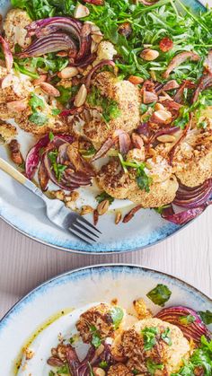 two plates filled with food on top of a white wooden table next to each other