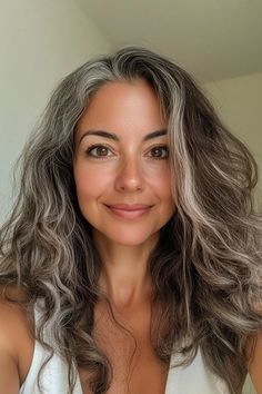 Ready for transitioning to gray hair? Our collection of stunning examples of women going grey naturally will convince you to make the switch. Tap to explore 25 pics of dark brown hair going grey, blonde gray transition ideas, and more or save this pin for later! Dark Brown Hair With Natural Gray, Grey Hair 40s Going Gray, Lowlights For Grey Hair Going Gray, Dark Brown Salt And Pepper Hair, Gray Around The Face, Hair Color Ideas For Brunettes With Gray Over 50, Long Wavy Gray Hair Over 50, Transition Grey Hair, Grey Blending Lowlights Brunette