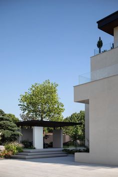 a building with a tree in the background and stairs leading up to it's entrance