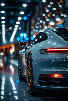 the rear end of a white sports car parked in a parking lot at night time