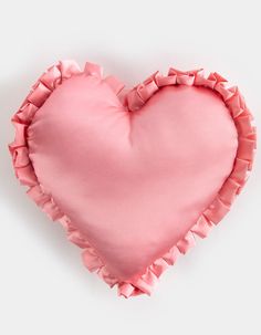 a pink heart shaped pillow with ruffled edges