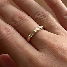 a person's hand with a gold ring on top of their finger and the word love written in it