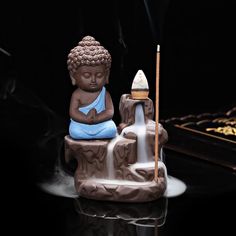 a buddha statue sitting on top of a table next to a incense burner and pipe