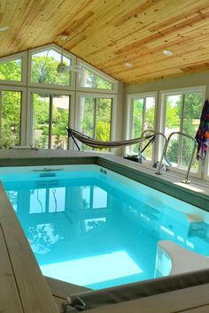 an indoor swimming pool with hammock and chairs