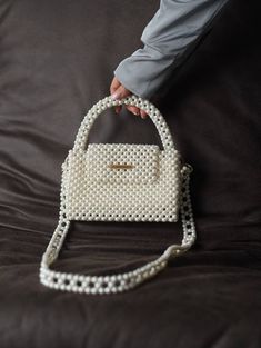 Handcrafted Beaded Pearl Bag - Elegance in Every Bead Unveil the epitome of timeless glamour with our exquisite Beaded Pearl Bag--a fusion of sophistication and craftsmanship that's perfect for the modern-day diva. Whether you're attending a wedding, a gala, or a stylish soirée, this beaded pearl bag is designed to elevate your outfit. It effortlessly transitions from day to night, making it a versatile accessory for every occasion. Despite its petite appearance, this bag is surprisingly spaciou Chic Pearl White Bag For Events, White Top Handle Evening Bag For Formal Events, Elegant Beaded Tote Shoulder Bag, Beige Pearl Bags For Gifts, Beige Pearl Bag For Gifts, White Top Handle Evening Bag, Elegant Tote Bag For Gift, White Shoulder Bag With Pearl Embroidery For Everyday, Elegant Square Handmade Shoulder Bag