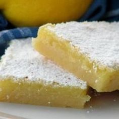 several pieces of cake sitting on top of a brown paper covered plate with powdered sugar