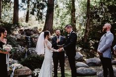 a bride and groom standing at the alter during their outdoor wedding ceremony in the woods