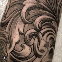 a close up of a person's arm with an artistic tattoo design on it