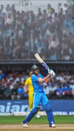 a man holding a baseball bat on top of a field in front of a crowd