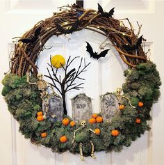 a wreath decorated with moss and halloween decorations