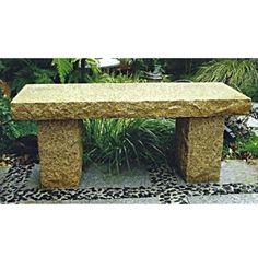 a stone bench sitting in the middle of a garden