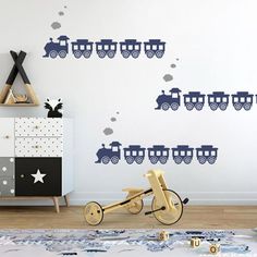 a child's room with a train wall decal on the wall and toys