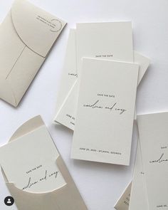 the wedding stationery is laid out on top of each other, including envelopes