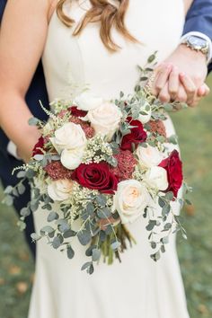 the bride and groom hold their bouquet together