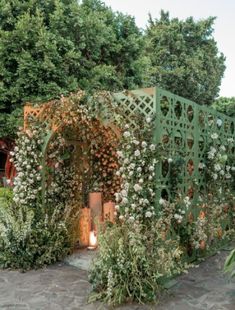 an outdoor area with flowers and greenery on the walls, surrounded by stone walkways