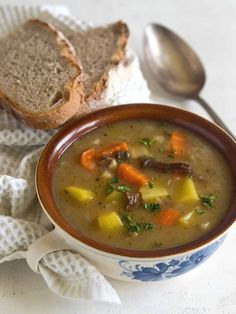 a bowl of soup with bread on the side