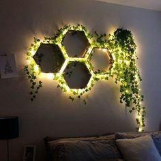 a bedroom with plants growing on the wall and lights in the corner above it that look like hexagons