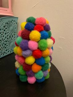 a stack of multicolored pom - poms sitting on top of a table