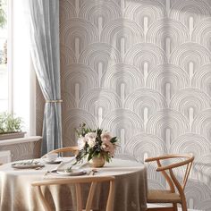 a dining room with a table and chairs in front of a wallpapered wall