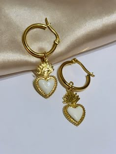 Are you looking for the perfect Valentine's day heart hoop earrings for someone special this Valentine's season? Or a unique pair of sacred heart earrings to spoil yourself? Made with tarnish-free and gold-plated stainless steel hoops and bright enamel, my vintage-style sacred heart earrings are the perfect compliment to any outfit idea! My heart dangle hoop earrings are a great gift idea for any special occasion to all the women in your life. You can't go wrong when gifting my Valentine's day e White Huggie Earrings For Valentine's Day, White Heart Pendant Earrings For Valentine's Day, White Heart Pendant Earrings, White Heart Charm Pendant Earrings, White Hoop Earrings With Heart Charm For Gift, White Hoop Earrings With Heart Charm, White Open Heart Earrings For Gift, Gift White Open Heart Earrings, White Dangle Hoop Earrings For Valentine's Day