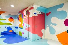 an artistic room with colorful paint on the walls and floor, painted in bright colors