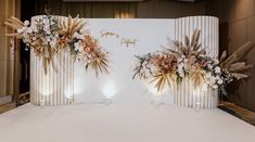 a white backdrop with flowers and candles on it