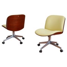 two office chairs with wheels on each side, one is yellow and the other is brown