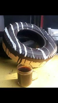 a cup of coffee sitting next to an old tire