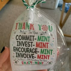 a hand holding up a plastic bag that says thank you for your commit - mintt