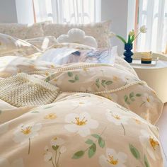 an unmade bed with flowers and pearls on it