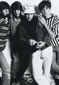 the rolling stones posing for a black and white photo in front of a striped wall