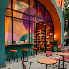 an outdoor cafe with tables, chairs and bookshelves in front of the window