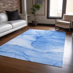 a living room with white couches and blue rug