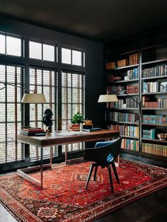 a room with lots of bookshelves and a rug on the floor in front of it