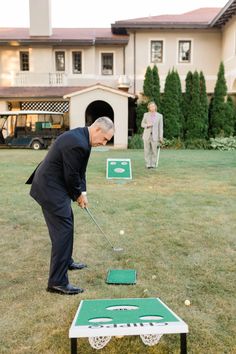 an older man is playing golf on the lawn with two other men in the background