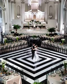 a bride and groom standing in the middle of a black and white wedding reception hall