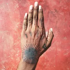 a person's hand with tattoos on it