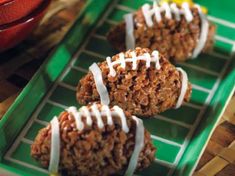 football cookies with white icing on a green tray