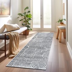 a white and black rug on the floor in front of a door with a bench