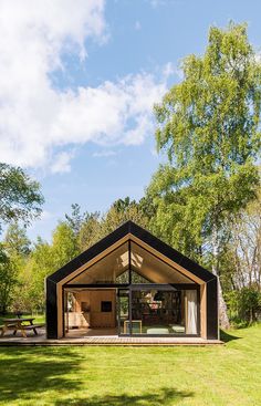 a small wooden structure sitting on top of a lush green field