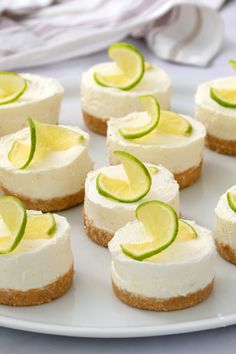 a white plate topped with mini cheesecakes covered in cucumber and lime