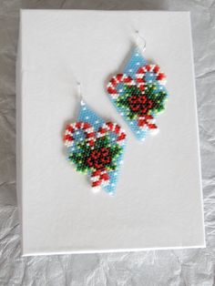 a pair of beaded earrings on top of a piece of paper